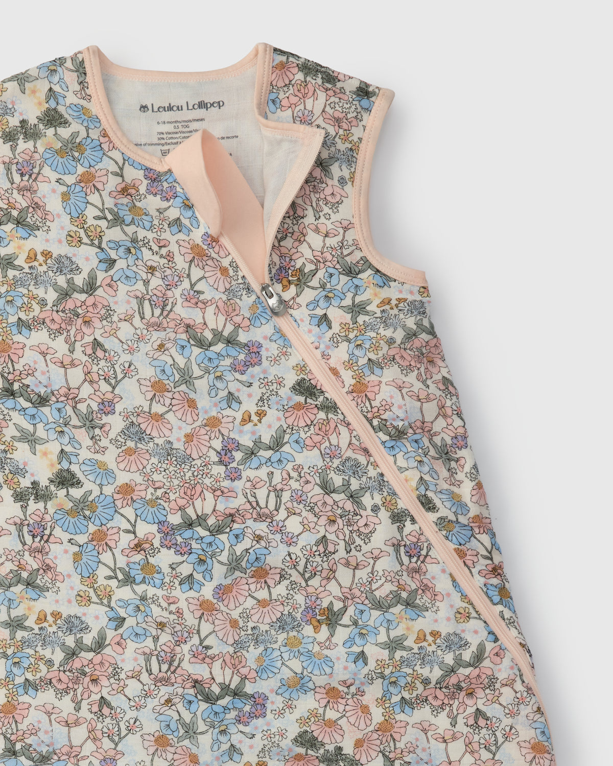 Floral patterned baby sleep bag with pink trim on a white background