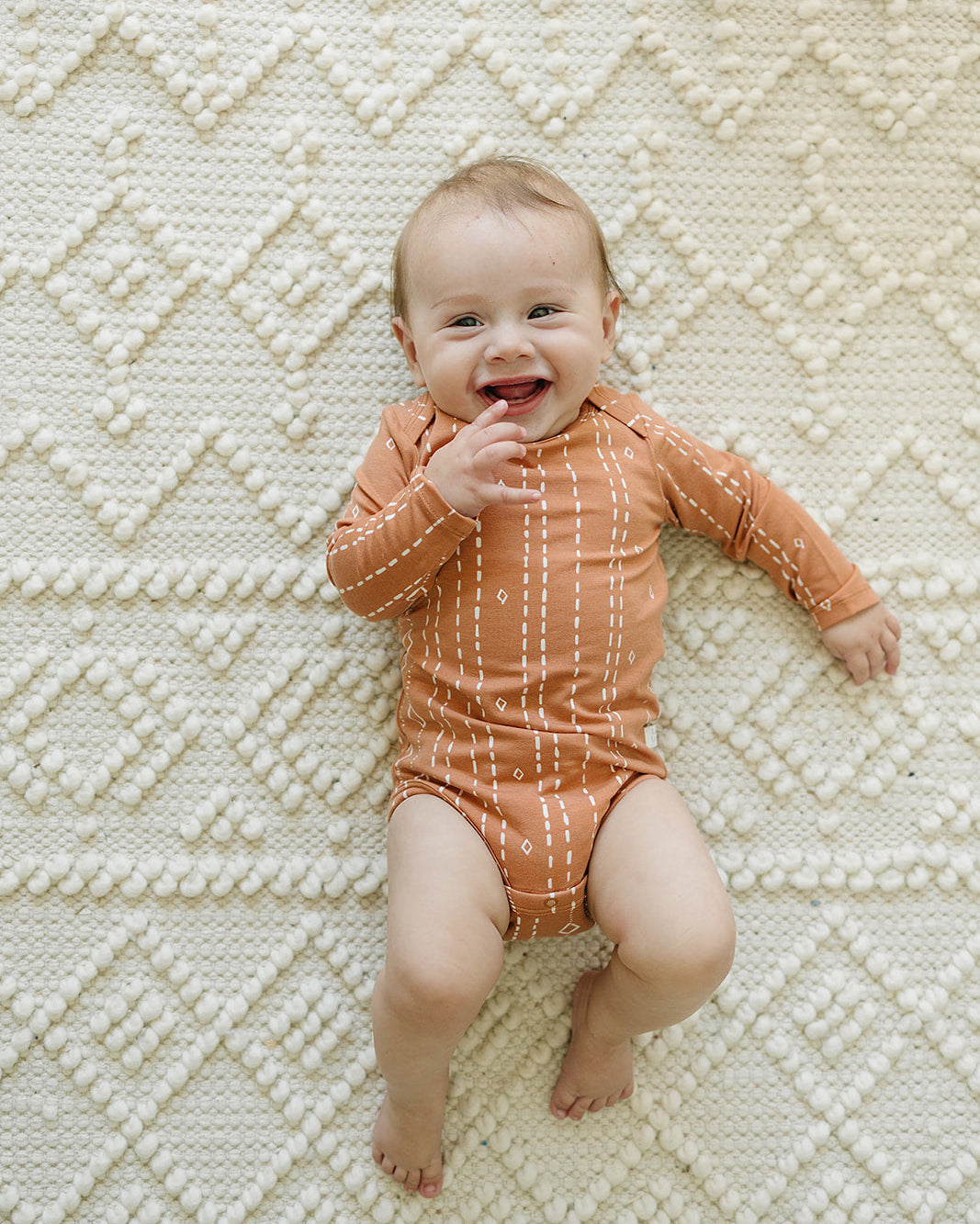 Loulou Lollipop Long Sleeve Ruffle Bodysuit in Rust Geo — front view on white background