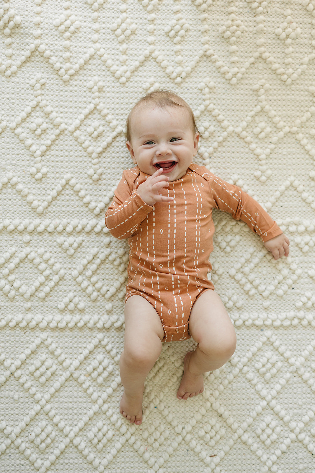 Loulou Lollipop Long Sleeve Ruffle Bodysuit in Rust Geo — front view on white background