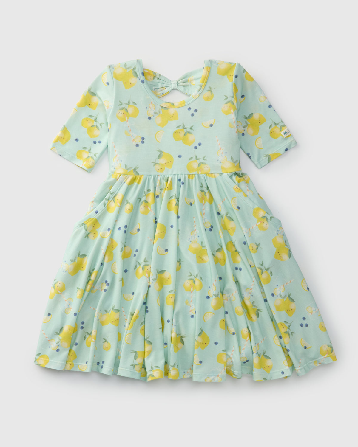 Green dress with yellow lemon pattern on a light gray background