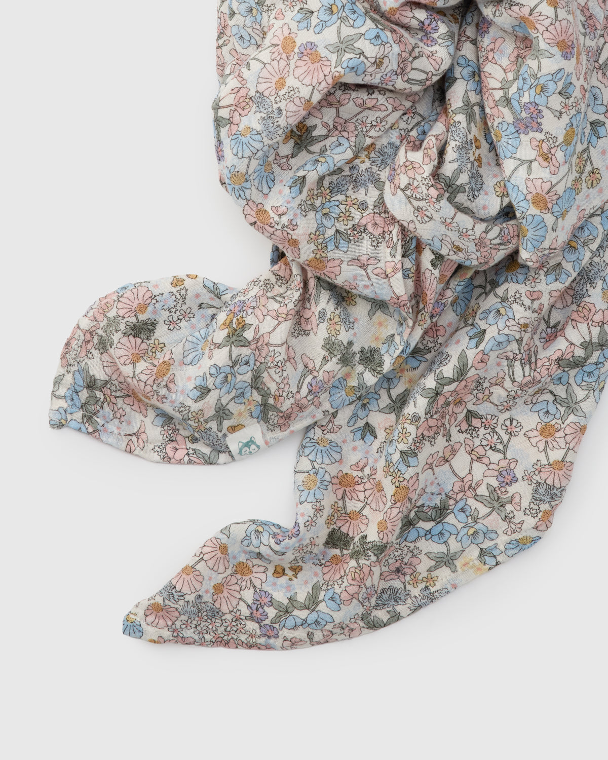 Floral patterned fabric muslin swaddle on a white background