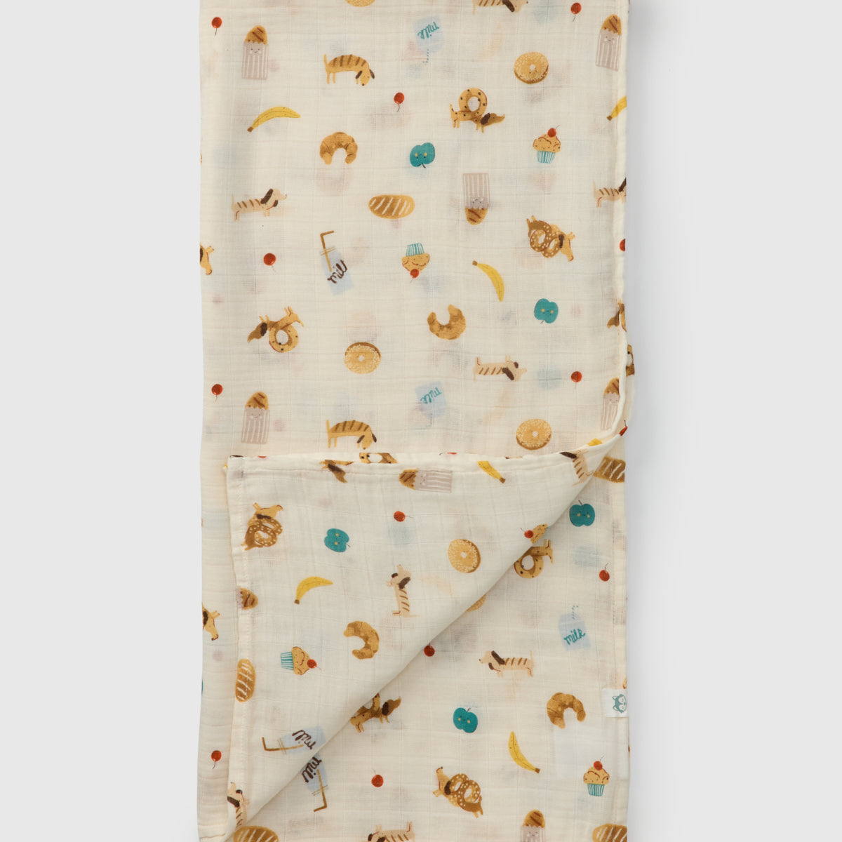 Folded fabric with food themed pretzel dog, milk bread pattern on a white background