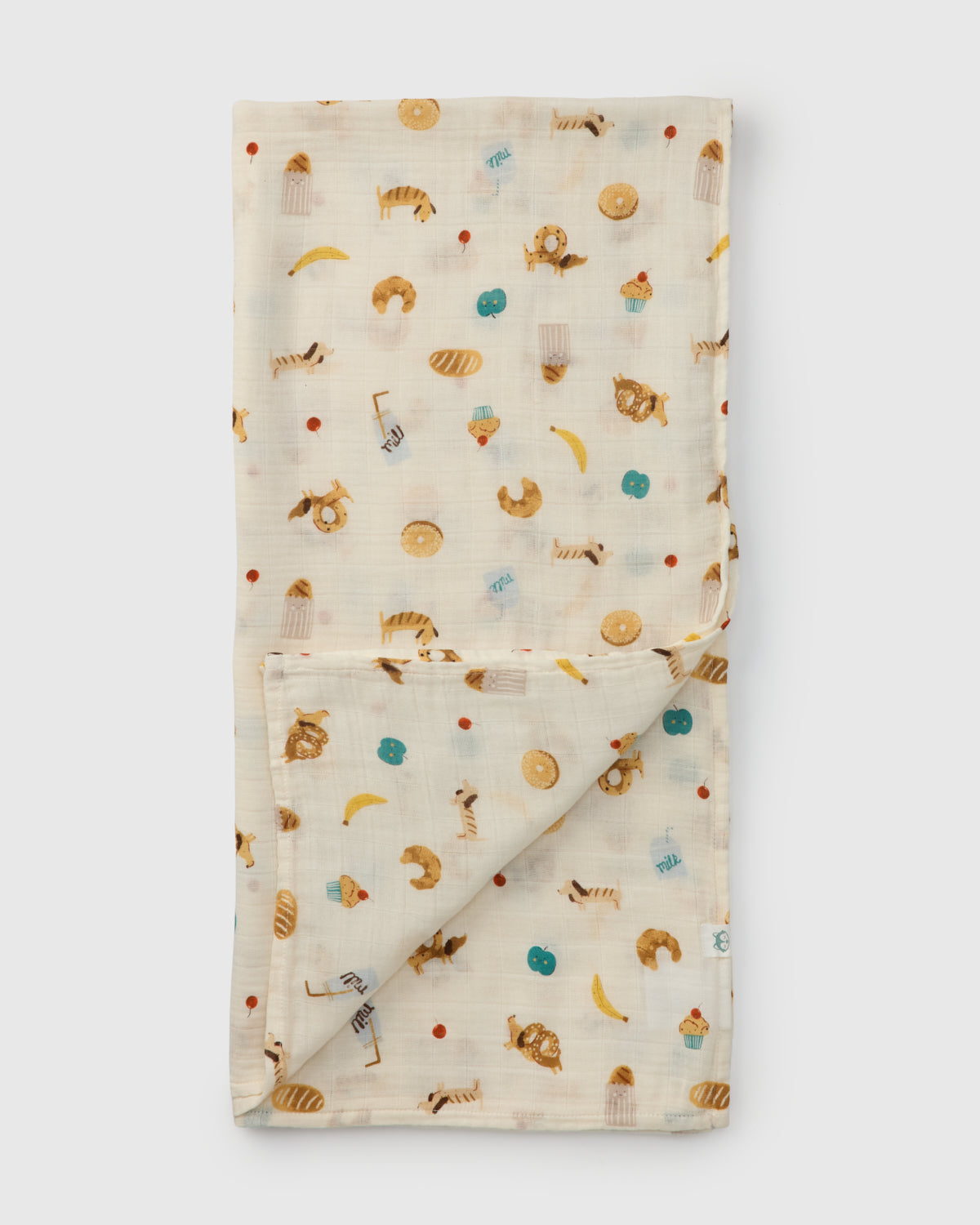 Folded fabric with food themed pretzel dog, milk bread pattern on a white background