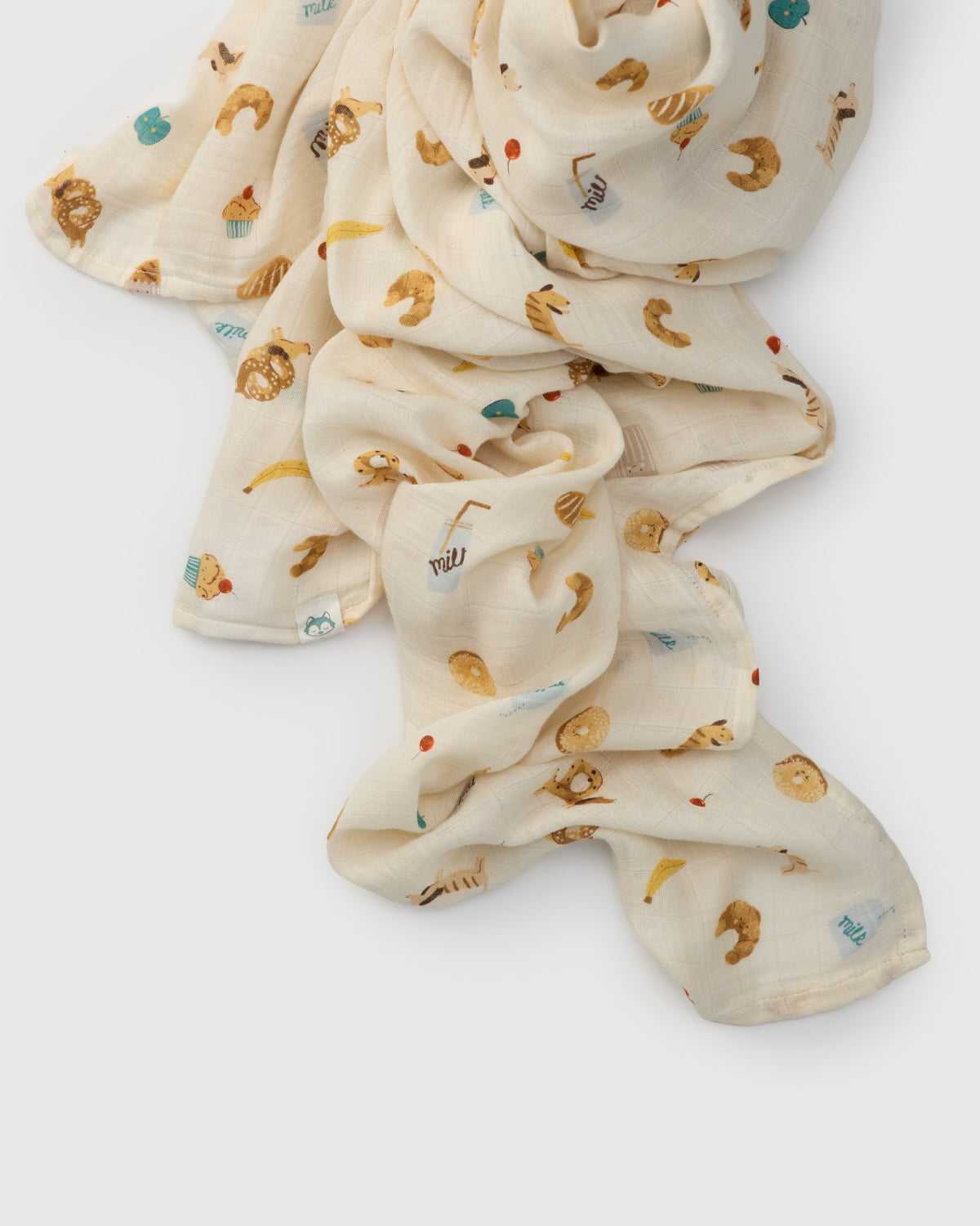 Folded fabric with food themed animal prints on a white background