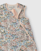 Floral patterned baby sleep bag with pink trim on a white background