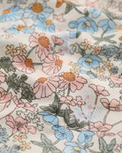Close-up of floral fabric with pink, blue, and green flowers.