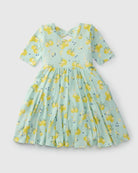Green dress with yellow lemon pattern on a light gray background