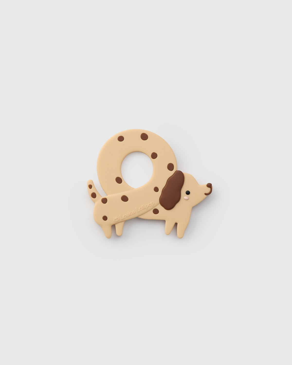 Dog-shaped teether with brown spots on a light gray background