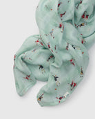 Light blue muslin swaddle  with small soccer printed designs on a white background