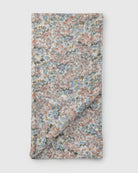 Floral-patterned fabric muslin swaddle on a white background